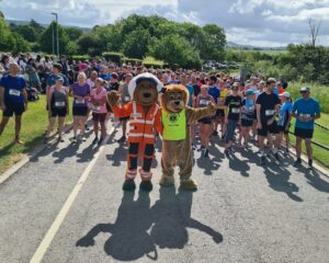 Wotton Lions mascot Roary, Charlie Bear from Great Western Air Ambulance at the start line of the 10,000m Under the Edge along with the runners